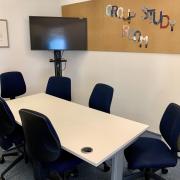Room with chairs round a table with presentation screen