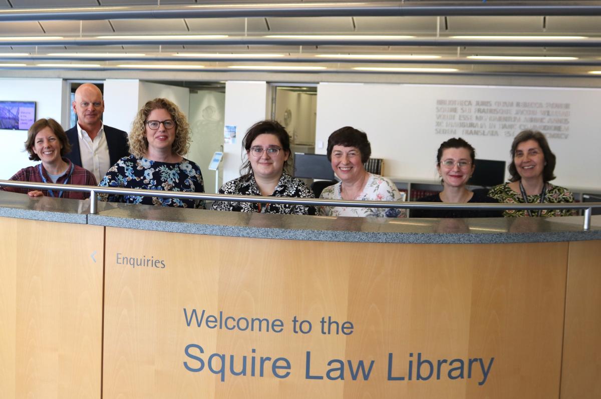 Members of the Squire Law Library team standing behind the Enquiry Desk
